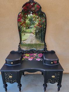 a vanity with a mirror on top of it next to a fence and flowered garden