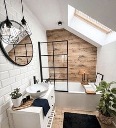 a bathroom with a sink, mirror and bathtub under a skylight in the corner