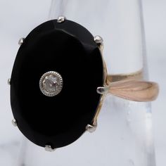 This antique Victorian 18k gold ring features a gorgeous large, faceted onyx adorned with a lovely Old European Cut 2.5mm diamond center. The stone is set with a 6-pronged, platinum tipped, triangle cut out gallery. This ring is a size 6, weighs 3.5 grams and measures 17mm tall. It is in excellent antique condition with light wear and is not marked but has been tested and is guaranteed. Black Heirloom Ring With Center Stone, Heirloom Black Ring With Center Stone, Black Single Diamond Wedding Jewelry, Classic Onyx Diamond Ring, Vintage Black Diamond Ring With Diamond Accents, Vintage Black Diamond Round Ring, Vintage Black Round Diamond Ring, Black Ring With Single Diamond In Fine Jewelry Style, Elegant Black Ring With Single Diamond