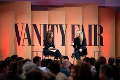 two women sitting on chairs in front of an audience at a vanity fair panel discussion