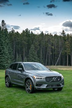 a silver volvo suv parked on top of a lush green field