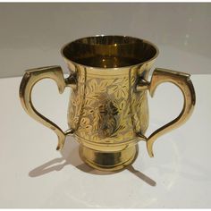 a gold colored cup sitting on top of a white table