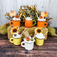 three mugs filled with whipped cream and sunflower decorations on top of a wooden table