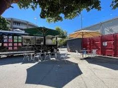 an outdoor dining area with tables and umbrellas