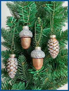 christmas ornaments are hanging from the tree in gold, silver and white glittered pine cones