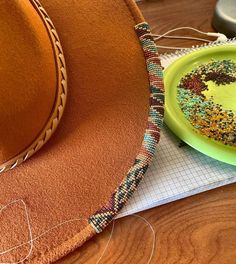 a yellow plate with a donut on it next to a cowboy hat and thread