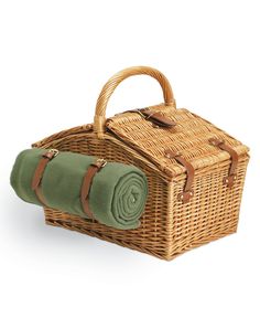 a wicker picnic basket with green blanket