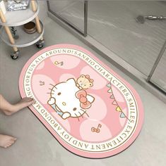 a hello kitty bathroom rug on the floor in front of a person's feet