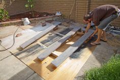 a man working on some wooden boards in the yard