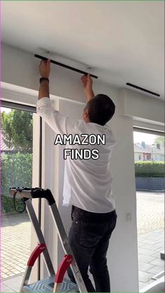 a man that is standing on a ladder in front of a window with the words amazon finds above him