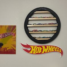 a hot wheels sticker is hanging on the wall next to a toy car display