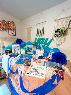 a bed covered in lots of blue and white items on top of a wooden table