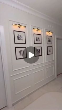 a white room with pictures on the wall and framed photos hanging on the walls above it