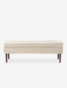 an upholstered bench with wooden legs