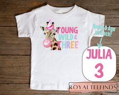 a white shirt with a giraffe wearing a birthday hat and name tag on it