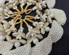 "Cowry or cowrie have historically been used as a currency in several parts of the world, but today extensively for jewellery and for other decorative and ceremonial purposes. Cowry shells are viewed as symbols of womanhood, fertility, birth and wealth. Beautiful beaded cowrie tassels with faux pearl circular applique and braided zari loop to attach. These tassels can be used for various craft work, to decorate bags, gift boxes... or for ethnic jewelry. Size : Total length of the tassel is 3.5\" White Beaded Shell For Festival, Latkan Ideas, Beaded Tassels Diy, Tassels Fashion Clothing, Decorated Bags, Cowry Shell, Diy Tassel, Fabric Earrings