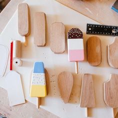 wooden spoons and popsicle shapes are arranged on a table with rulers, pencils, and other crafting supplies