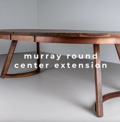 an oval wooden table with the words murray round center extension on it's side