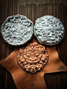 two carved plates sitting on top of a wooden table