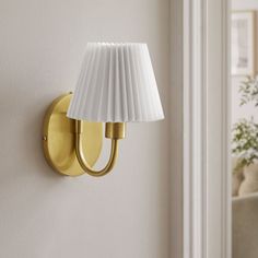 a wall light with a white shade on it in a living room or dining room