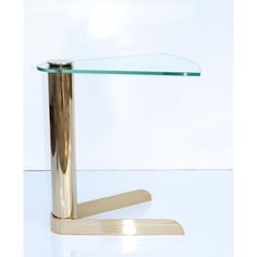 a table with a glass top and gold base