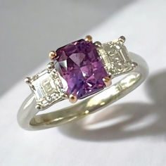 iful purple sapphire and diamond 3-stone ring features a natural, 2.14 carat unheated purple-colored sapphire set with perfectly-matched, D-color Asscher-cut diamonds! The sapphire is a natural medium purple color with lovely pinkish highlights. It is a modified emerald-cut with brilliant-cut facets on the crown; this octagonal shape is complemented beautifully with the half-carat Asscher cut diamonds on either side. As most sapphires on the market have been heated to bring out their best color. Luxury Brilliant Cut Amethyst Gemstones, Luxury Multi-stone Birthstone Ring With Round Cut, Purple Sapphire Zales, Luxury Cushion Cut Amethyst Ring With Prong Setting, Asscher Cut Diamond, 3 Stone Rings, Purple Sapphire, Asscher Cut, Medium Purple