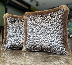 two leopard print pillows sitting on top of a table