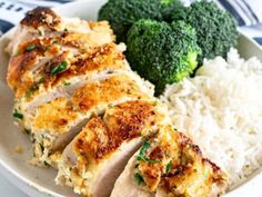 a white plate topped with chicken and rice next to broccoli on a blue and white table cloth