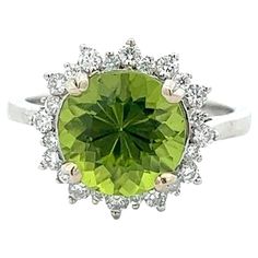 A wonderful 3.24 carat peridot stone set within a halo of diamonds in 14k white gold. The peridot came straight from the Peridot Mesa Gem Mine in Peridot, Arizona and has a unique round cut that reflects light well. The ring is brand new and a size 6.75, but can easily be resized. Formal Peridot Diamond Ring With Prong Setting, Formal Peridot Diamond Ring With Center Stone, Gem Mining, Light Well, Peridot Stone, Stone Settings, Cocktail Rings, Round Cut, Halo