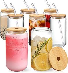 there are many different types of drinks in glass jars with lids and straws on each one