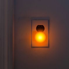 a light that is on in the wall next to a door way with a button