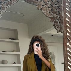 a woman taking a selfie in front of a mirror