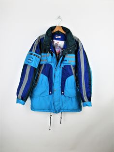 Fila Ski Team Italia vintage 90s padded ski jacket, blue, light blue, green and gray, hood inside the collar, 6 front pockets with zip and 1 on the arm Size XL Measures: Neck/wrist length: 82 cm Length: 83 cm Armpit to armpit width: 67 cm PERFECT - No signs of wear Our garments are all vintage and second-hand. Any signs of wear or defects are documented with photos and description. For any questions, photos, videos we are at your disposal. Blue Nylon Winter Parka, Urban Blue Parka For Streetwear, Blue Nylon Parka For Winter, Urban Blue Parka With Pockets, Urban Blue Winter Parka, Blue Nylon Parka For Outdoor Activities, Blue Streetwear Parka With Pockets, Blue Parka With Pockets For Streetwear, Blue Parka With Pockets For Outdoor Activities