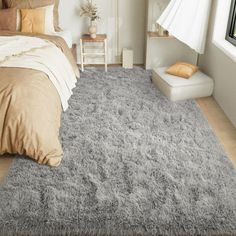 a bed room with a neatly made bed and a gray rug