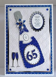 a blue and white birthday card with a wine bottle on the front that says 65