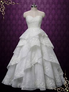 a white wedding dress on display in front of a purple background