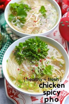 two bowls of chicken pho soup on a red and white plate with green garnish