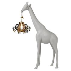 a white giraffe with a chandelier hanging from it's neck