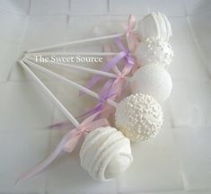 there are some white cake pops with pink bows on them and the words sweet source above it