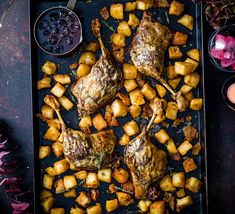 meat and potatoes on a baking sheet with dipping sauce