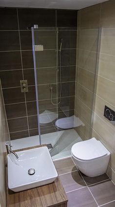 a bathroom with a toilet, sink and stand up shower stall in it's corner