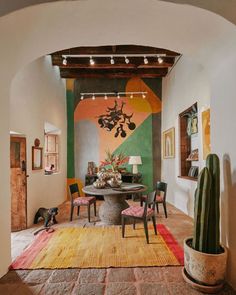 an archway leads to a dining room with cactus and succulents on the table