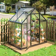 a small green house sitting on top of a lush green field