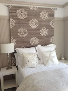 a white bed sitting next to a window with curtains on top of the headboard