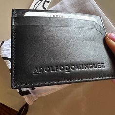 Nwt, Card Holder. Diagonal Cut Detail. Organic Cotton Lining. Engraved Logotype. Height X Width X Depth: 7,5 X 5 X 10,5 Cm Leather Working Group (Lwg) Tanned Leather Details And Care Main: 100% Cotton, Secondary: 100% Polyester, Outershell: 100% Bovine Leather Style Is Unisex Authentic Adolfo Dominguez Item. Was Originally Purchased In Madrid, Spain At The Boutique. Original Shopping And Drawstring Bag Included As Shown All Sales Are Final. Classic Black Wallet With Engraved Logo, Black Leather Card Holder With Engraved Logo, Black Leather Card Holder With Embossed Logo, Black Leather Wallet With Engraved Logo, Black Leather Wallets With Engraved Logo, Modern Black Card Holder With Engraved Logo, Black Leather Wallet With Embossed Logo, Black Rectangular Card Holder With Engraved Logo, Black Rectangular Wallet With Engraved Logo