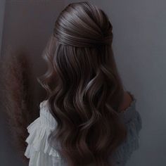 the back of a woman's head with long, wavy hair