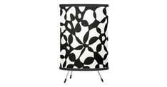 a black and white lamp shade with an abstract design on the bottom, in front of a white background