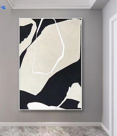 a white and black painting hanging on the wall