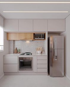 a kitchen with white cabinets and stainless steel appliances in the center, along with a microwave on the wall