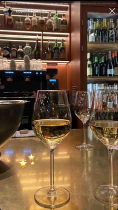 three wine glasses sitting on top of a table